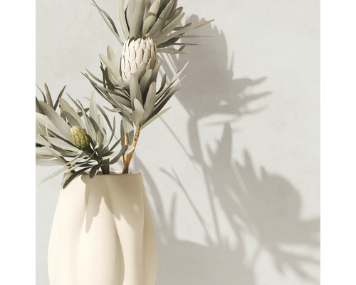 Künstliche Protea-Pflanze mit spitzen Blättern in einer modernen Keramikvase.