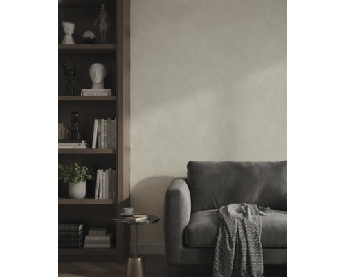 Wohnzimmer mit grauem Sofa, strukturiertem Wandputz, Holzregal und Beistelltisch.