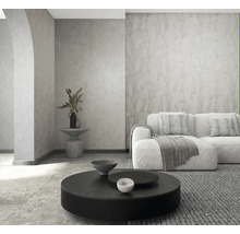 Modernes Wohnzimmer mit strukturierter Tapete, Sofa, rundem Couchtisch und Steinboden. Hell und organisiert.