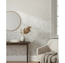 Vliestapete mit dezentem geometrischem Muster in einem hellen, modern eingerichteten Wohnraum mit Holztisch, Spiegel und Sessel.