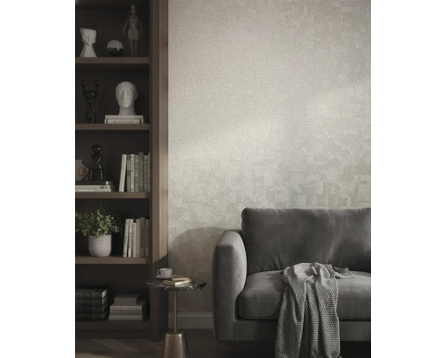 Strukturierte Vliestapete in einem modernen Wohnzimmer hinter einem grauen Sofa und neben einem dunklen Holzregal.