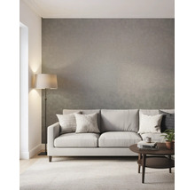 Helles, modernes Wohnzimmer mit strukturierter Tapete, Stoffsofa mit Kissen, Stehlampe und rundem Couchtisch auf einem Teppich.