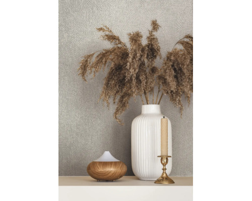 Strukturierte Tapete hinter einer Dekoration mit einer geriffelten Vase mit Trockengras, einem Diffuser in Holzoptik und einem Kerzenständer.