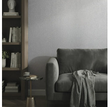 Modernes Wohnzimmer mit strukturierter Tapete, Samtsofa und Bücherregal aus Holz.