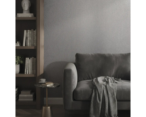 Wohnzimmer mit strukturierter Tapete, Samtsofa, Holzregal und Beistelltisch.