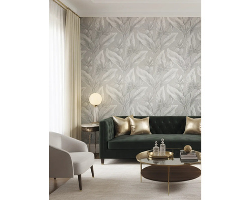 Modernes Wohnzimmer mit Tapete mit großem tropischem Blattmuster, Samtsofa und eleganten Möbeln.