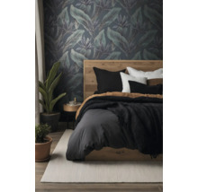 Modernes Schlafzimmer mit Vliestapete mit tropischem Blattmuster, Holzbett, Bettwäsche und Zimmerpflanzen.
