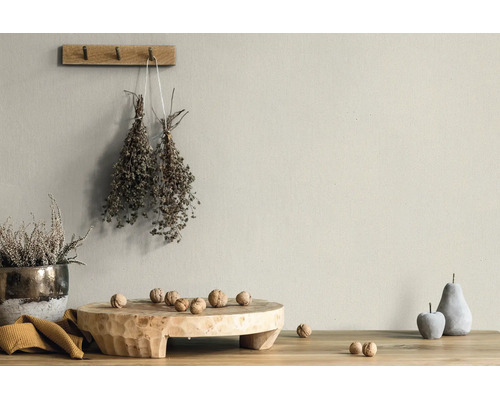Matte Wandfarbe in beigem Naturton in einem hellen, rustikalen Raum mit Holzdekoration und Trockenpflanzen.