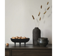 Sideboard aus dunklem Holz mit einer dekorativen schwarzen Schale auf drei Beinen gefüllt mit Walnüssen, einer Vase mit Trockengras und einem Topf.