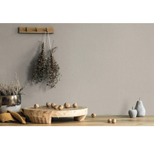 Wandfarbe in Taupe in einem rustikalen Wohnambiente mit Holzbrett, Walnüssen und getrockneten Kräutern.