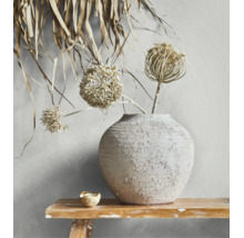 Strukturierte Keramikvase mit getrockneten Allium-Blüten auf einer rustikalen Holzbank.
