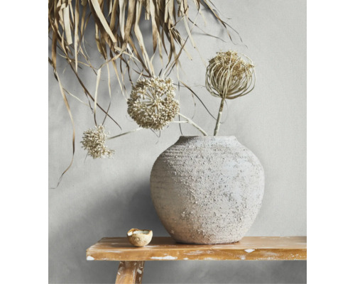 Strukturierte Keramikvase mit getrockneten Allium-Blüten auf einer rustikalen Holzbank.