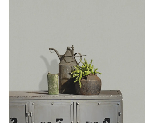Strukturierte graue Tapete in einem Raum mit Metallschrank im Industriestil und Vintage-Dekoration.