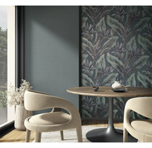 Vliesfototapete mit Dschungel-Motiv und tropischen Blättern in einem modernen Essbereich mit Holztisch und geschwungenen Stühlen.