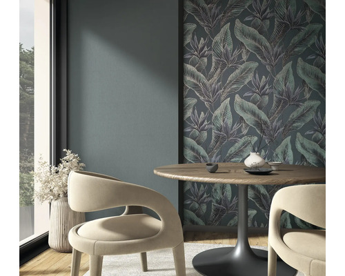 Vliesfototapete mit Dschungel-Motiv und tropischen Blättern in einem modernen Essbereich mit Holztisch und geschwungenen Stühlen.