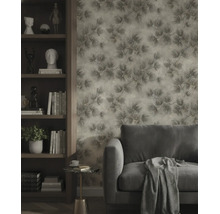 Vliestapete mit strukturiertem Zweigmuster in einem modern eingerichteten Wohnzimmer mit Sofa und Holzregal.