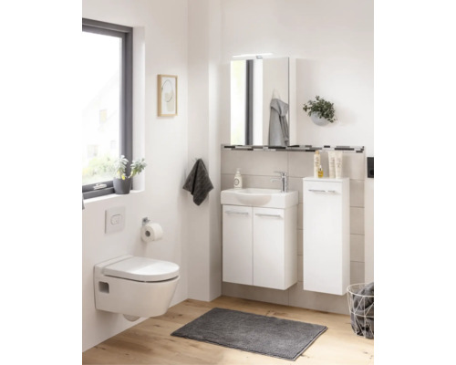Helles Badezimmer mit weißem wandhängendem WC, Waschbeckenunterschrank, Spiegelschrank, Seitenschrank und Holzoptik-Boden.