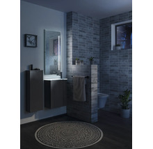 Modernes Badezimmer mit Waschtischunterschrank, Hochschrank, beleuchtetem Spiegel, Wandtoilette, dunkelgrauen Fliesen und gemustertem Teppich.