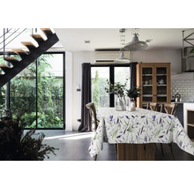 Helles Esszimmer mit Esstisch, Lavendel-Tischdecke, Holzstühlen, Industrie-Pendelleuchten und moderner schwarzer Treppe sowie Blick in den Garten.