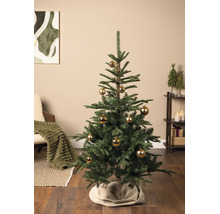 Künstlicher Tannenbaum mit goldenen Weihnachtskugeln in einem hellen Wohnzimmer mit Holzboden, beigem Teppich und gemütlicher Dekoration.