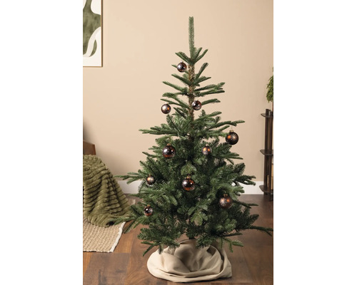 Künstlicher Weihnachtsbaum dekoriert mit braunen Weihnachtskugeln mit Sternenmotiv in einem Wohnzimmer.