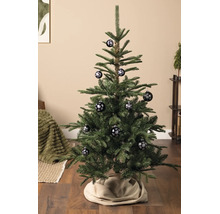 Weihnachtsbaum in einem hellen Wohnraum, geschmückt mit Christbaumkugeln mit Schneeflocken-Motiv.