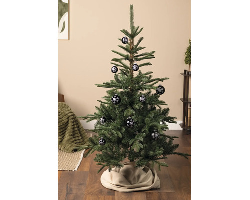 Weihnachtsbaum in einem hellen Wohnraum, geschmückt mit Christbaumkugeln mit Schneeflocken-Motiv.