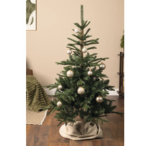 Weihnachtsbaum mit champagnerfarbenen Kugeln und Schneeflockenmuster in einem Wohnzimmer auf Holzboden.