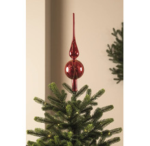 Christbaumspitze aus Glas in Rot auf der Spitze eines beleuchteten Weihnachtsbaums.