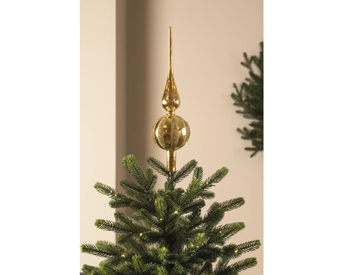 Goldene Christbaumspitze aus Glas mit glänzenden und glitzernden Streifen auf einem Tannenbaum.