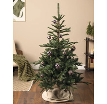Ein künstlicher Weihnachtsbaum geschmückt mit karierten Kugeln in einem hellen, aufgeräumten Wohnzimmer.