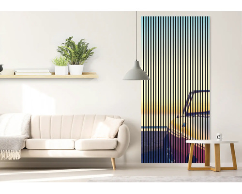 Moderner Wohnraum mit vertikaler Fototapete, die ein Auto bei Sonnenuntergang mit schwarzem Streifendesign zeigt, neben einem beigen Sofa.