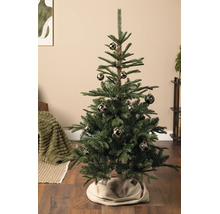 Geschmückter künstlicher Weihnachtsbaum mit dunklen Christbaumkugeln mit Karomuster in einem Wohnraum mit Holzboden.