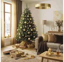 Festlich geschmückter Weihnachtsbaum mit goldenen Kugeln in einem hellen Wohnzimmer mit Sofa, Couchtisch und Weihnachtsdekoration.