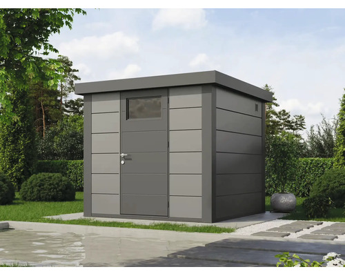 Modernes graues Metall-Gartenhaus mit Flachdach und Einzeltür mit Fenster in einem Garten mit Rasen, Hecken und einem Wasserbecken im Vordergrund.