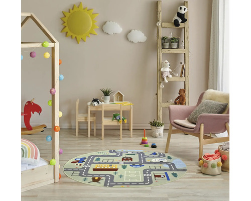 Hell gestaltetes Kinderzimmer mit rundem Spielteppich mit Straßenmotiv, Hausbett aus Holz, Kindersitzgruppe, Leiterregal und Sessel.
