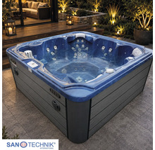 Quadratischer Außenwhirlpool auf einer beleuchteten Terrasse bei Nacht mit Massagejets, Kopfstützen und grauer Verkleidung.