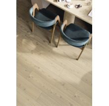 Laminatboden in heller Holzoptik mit Maserung im Essbereich unter zwei Stühlen und einem Tisch.