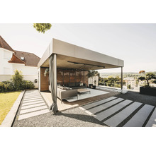 Moderne, helle Pergola aus Metall mit Holzlamellenwand, Vorhängen und Lounge-Möbeln auf einer Holzterrasse im Garten.