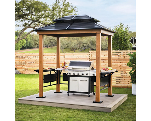 Grillpavillon aus Holz mit zweistufigem Metalldach, integrierten Ablagetischen und großem Gasgrill auf einer Garten-Terrasse.