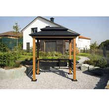 Grillpavillon mit dunklem Doppeldach, hellen Holzpfosten und integrierten Seitenablagen in einem modern gestalteten Garten vor einem Wohnhaus.