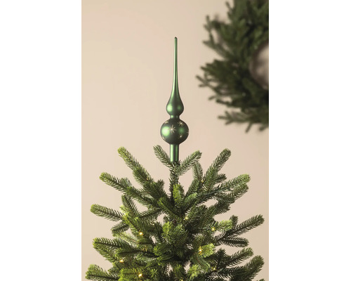Christbaumspitze mit Sternenmuster auf einem künstlichen Weihnachtsbaum mit Beleuchtung.