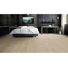 Modernes Schlafzimmer mit hellem Holzboden, einem Doppelbett mit weißer Bettwäsche und einer dunklen, strukturierten Wand.