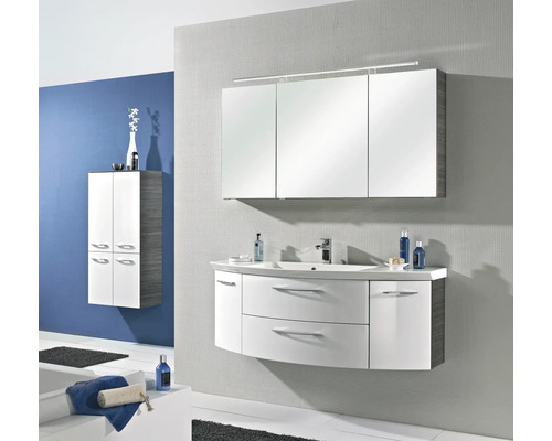 Modernes Badezimmer-Set mit weißem, geschwungenem Waschbeckenunterschrank, dreitürigem Spiegelschrank mit Beleuchtung und passendem Hochschrank.