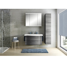Modernes Badezimmer mit Waschtischunterschrank in Holzoptik, weißem Waschbecken, Spiegelschrank mit Beleuchtung und passendem Hochschrank.