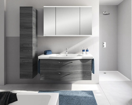Modernes Badmöbel-Set mit dunklem Waschtischunterschrank, weißem Keramikwaschtisch, dreitürigem Spiegelschrank und Hochschrank in hellem Badezimmer.