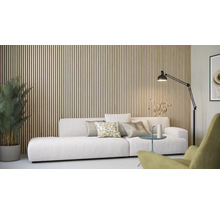 Akustikpaneele aus Holzlamellen an einer Wand im Wohnzimmer hinter einem Sofa mit Kissen, einem Beistelltisch und einer Stehlampe.