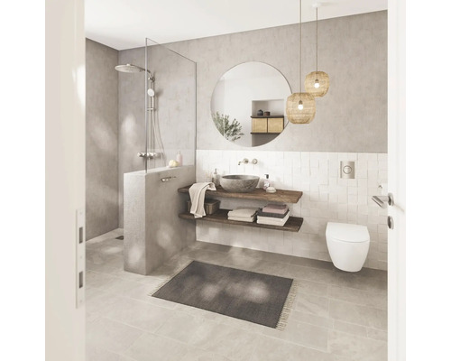 Modernes, helles Badezimmer mit ebenerdiger Dusche, rundem Spiegel, Holzregalen mit Steinwaschbecken und wandhängender Toilette.