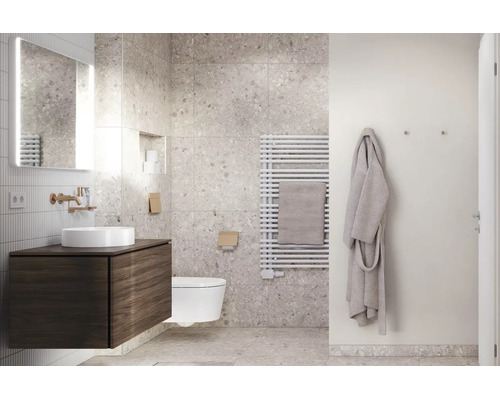 Modernes Badezimmer mit Fliesen in Terrazzo-Optik, dunklem Waschtischunterschrank mit Aufsatzwaschbecken, Wand-WC und weißem Handtuchheizkörper.