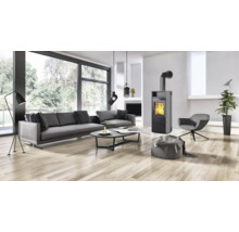 Moderner Wohnraum mit Kaminofen, großem Sofa, Sessel und Parkettboden in heller und offener Gestaltung.